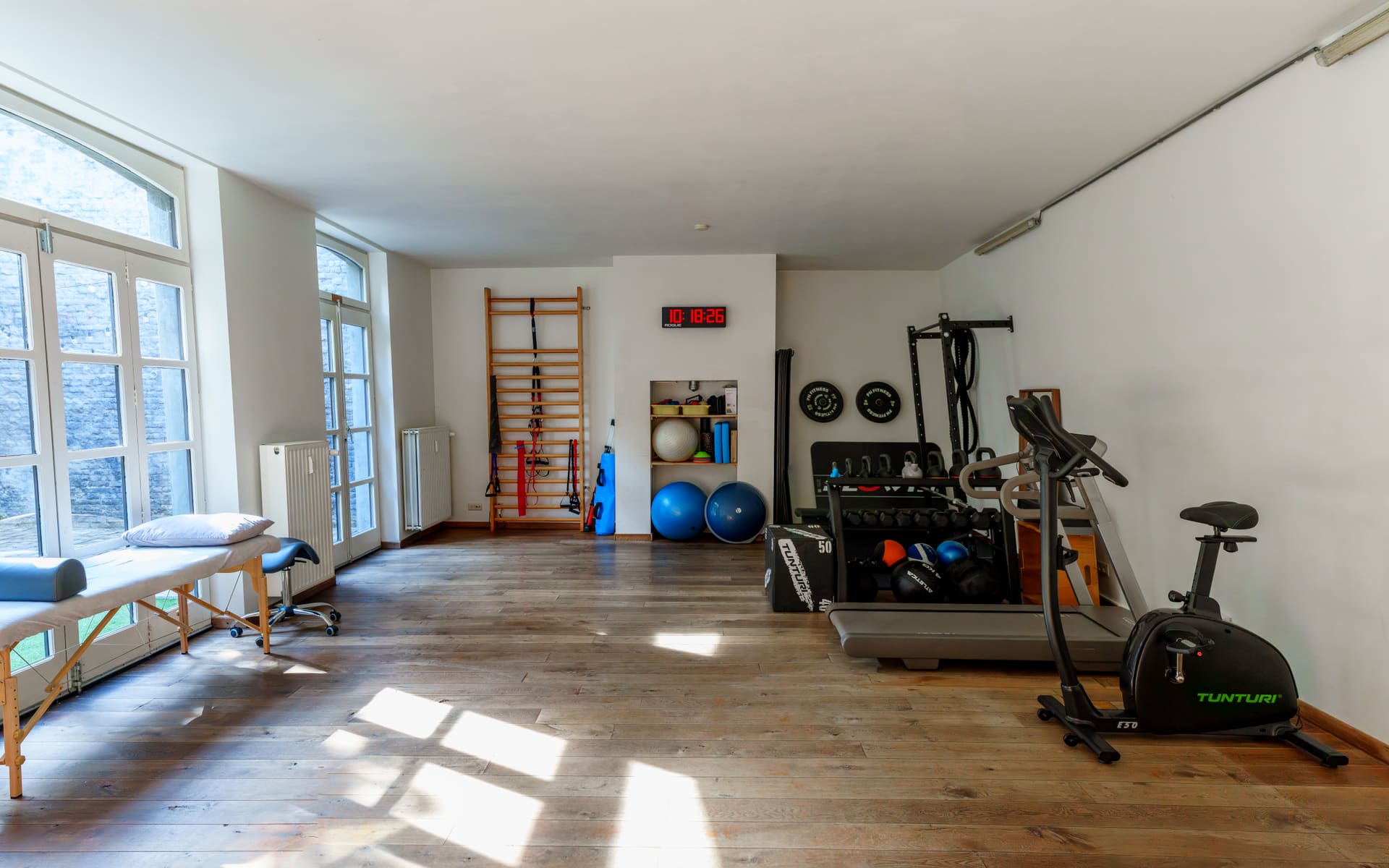 Panoramisch zicht op de oefenzaal met houten vloer en trainingsmateriaal